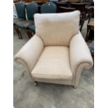 A MODERN UPHOLSTERED EASY CHAIR ON TURNED FRONT LEGS, WITH BRASS CASTERS, 36" WIDE