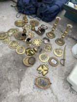 AN ASSORTMENT OF VINTAGE BRASS ITEMS TO INCLUDE HORSE BRASSES AND CANDLESTICKS ETC