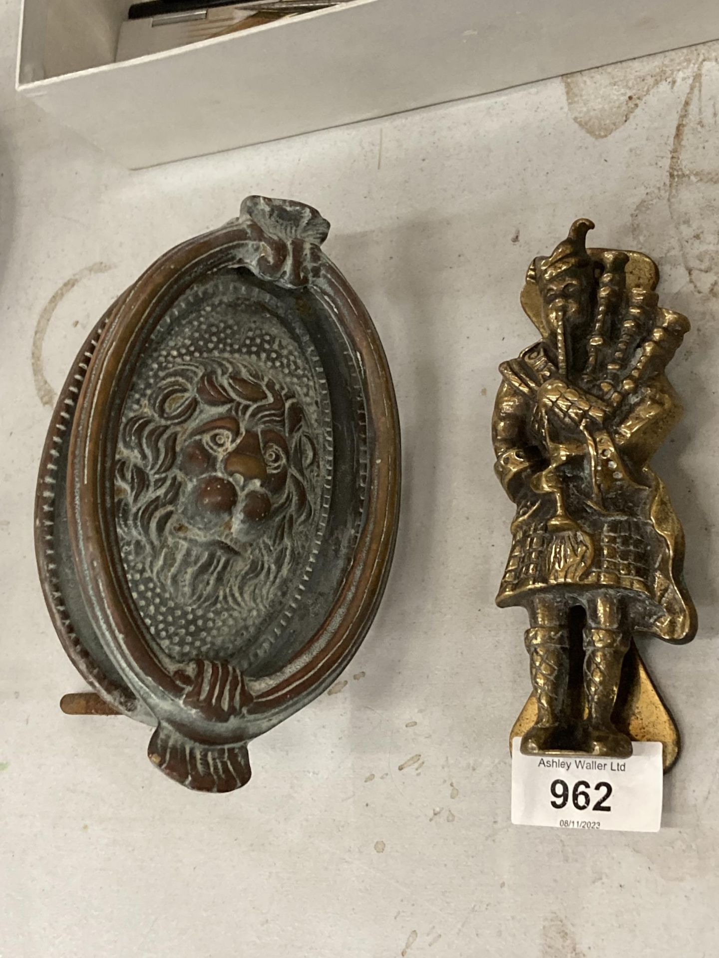 TWO VINTAGE BRASS DOOR KNOCKERS, ONE A LION, THE OTHER A SCOTSMAN