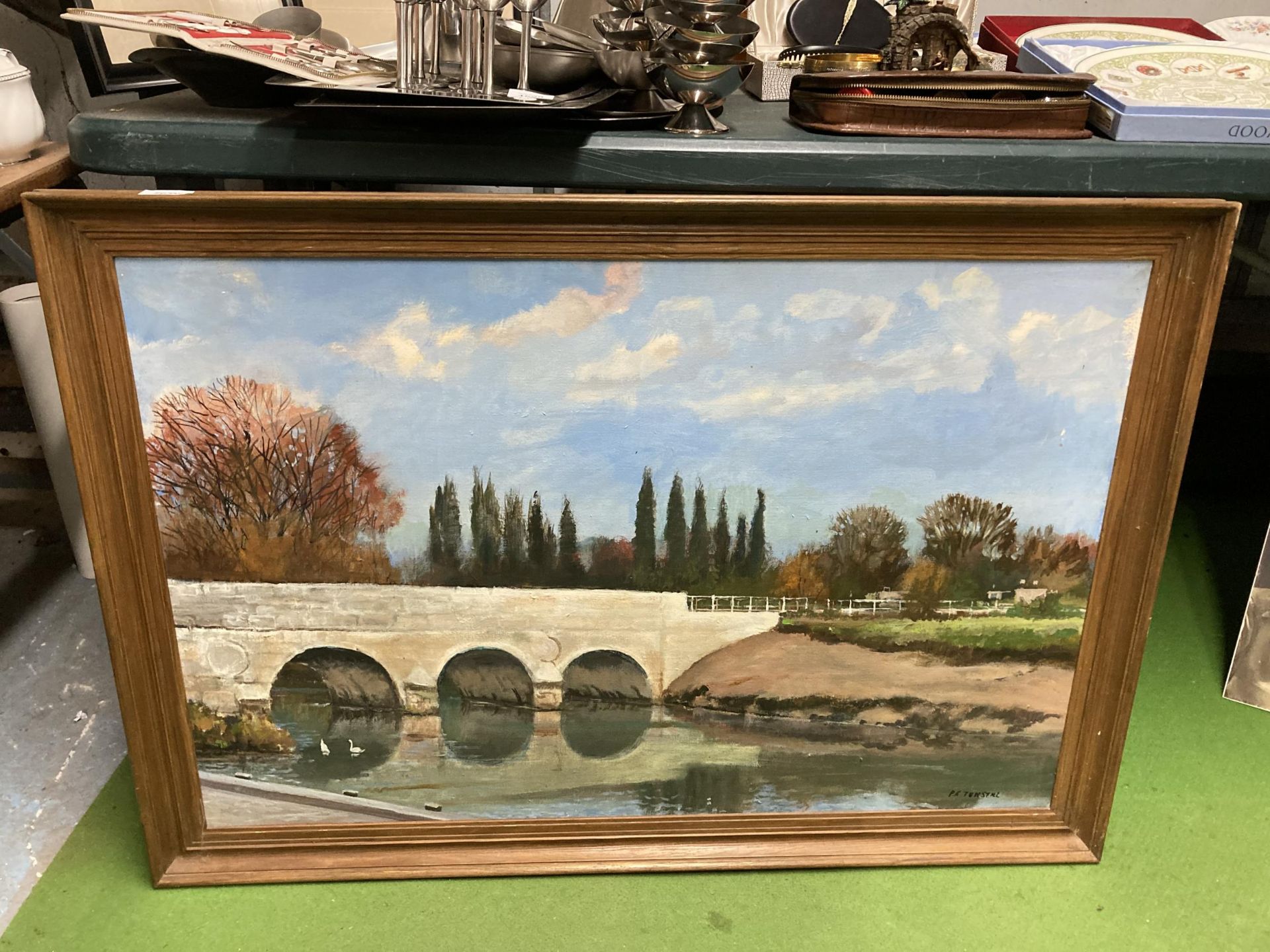 A LARGE OIL ON CANVAS OF A RIVER AND BRIDGE SCENE, SIGNED P F TUNSTALL, 101CM X 71CM