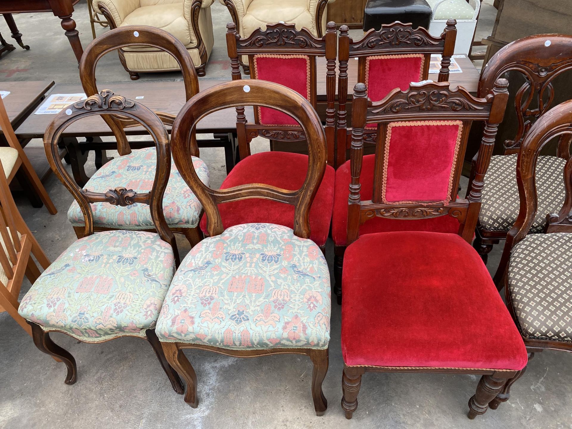 THREE VICTORIAN MAHOGANY DINING CHAIRS WITH CARVED BACK RAILS AND THREE BALLOON BACK CHAIRS