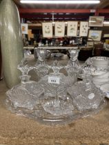 A GLASS DRESSING TABLE SET TO INCLUDE A TRAY, CANDLESTICKS, BOTTLES WITH STOPPERS AND A RING HOLDER