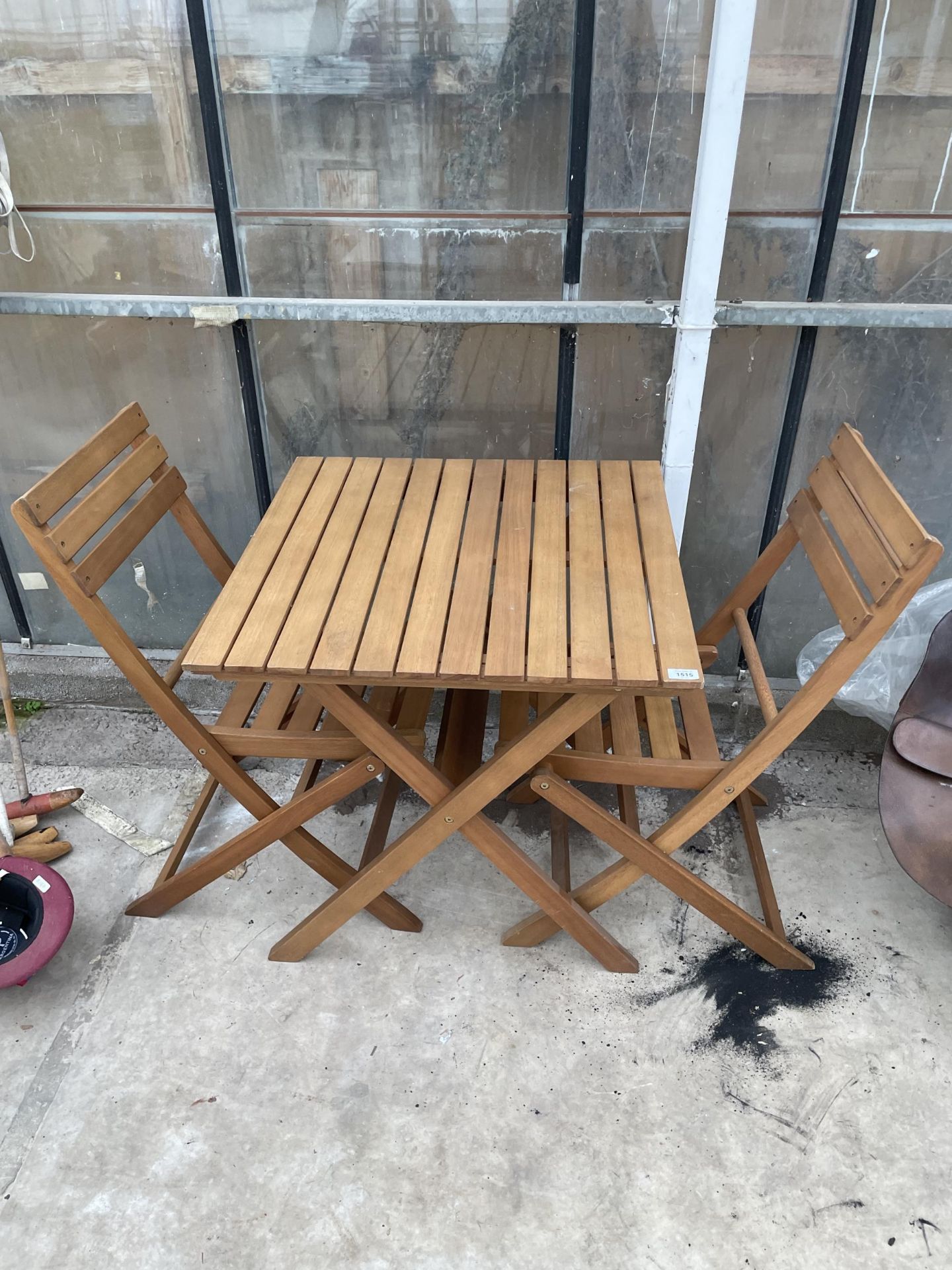 A WOODEN FOLDING BISTRO TABLE AND TWO CHAIRS