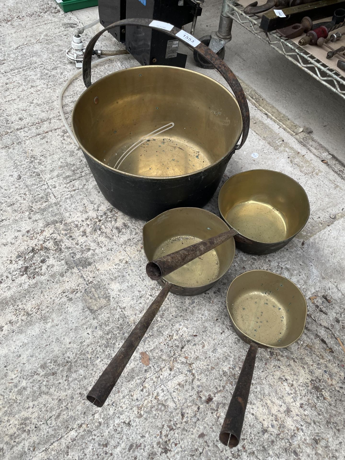 A LARGE BRASS JAM PAN AND THRE GRADUATED PANS WITH STEEL HANDLES