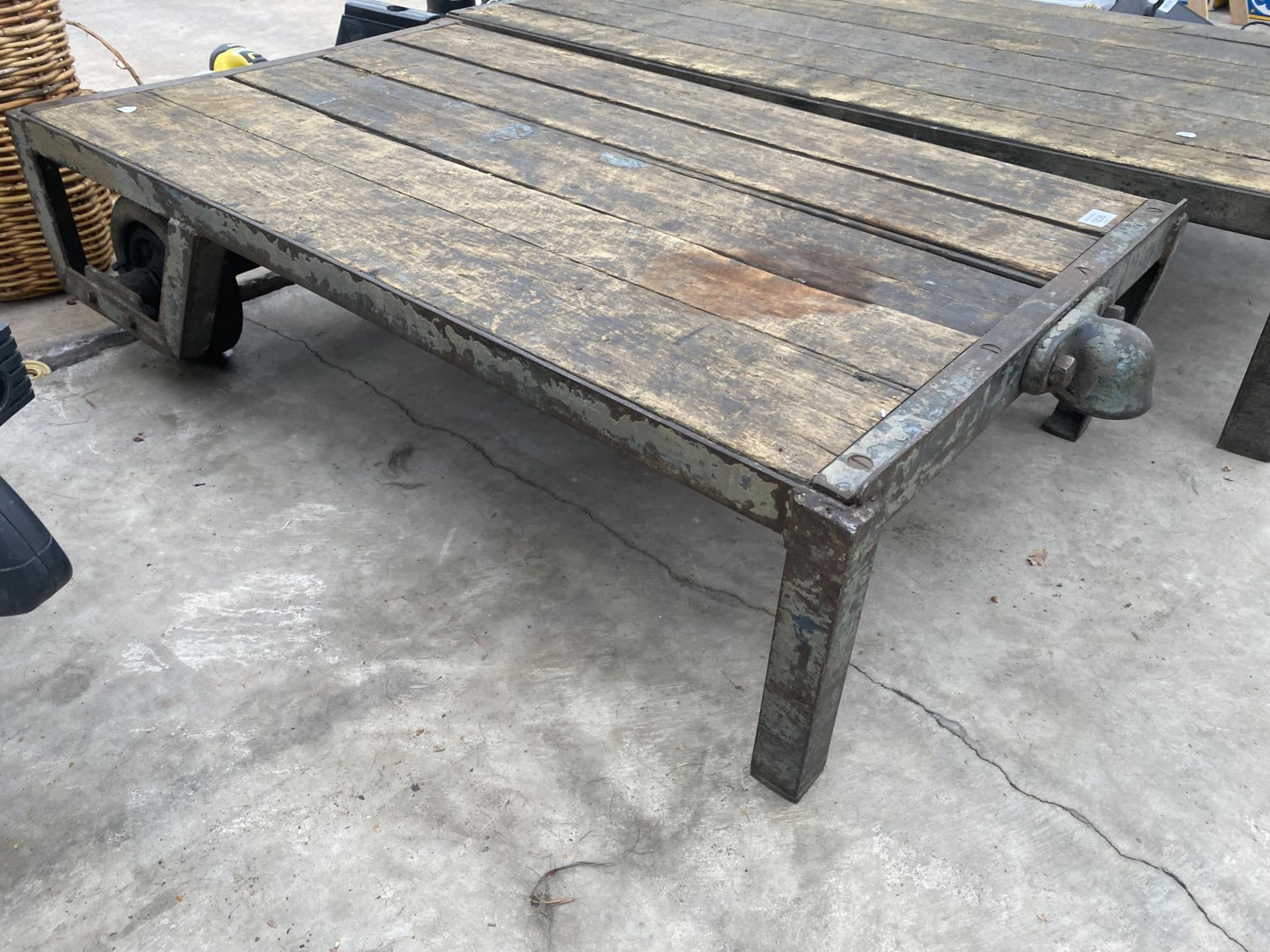 A VINTAGE WOODEN AND METAL TWO WHEELED PLATFORM TROLLEY