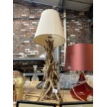 A TABLE LAMP AND SHADE WITH THE BASE MADE FROM DRIFTWOOD/TWIGS