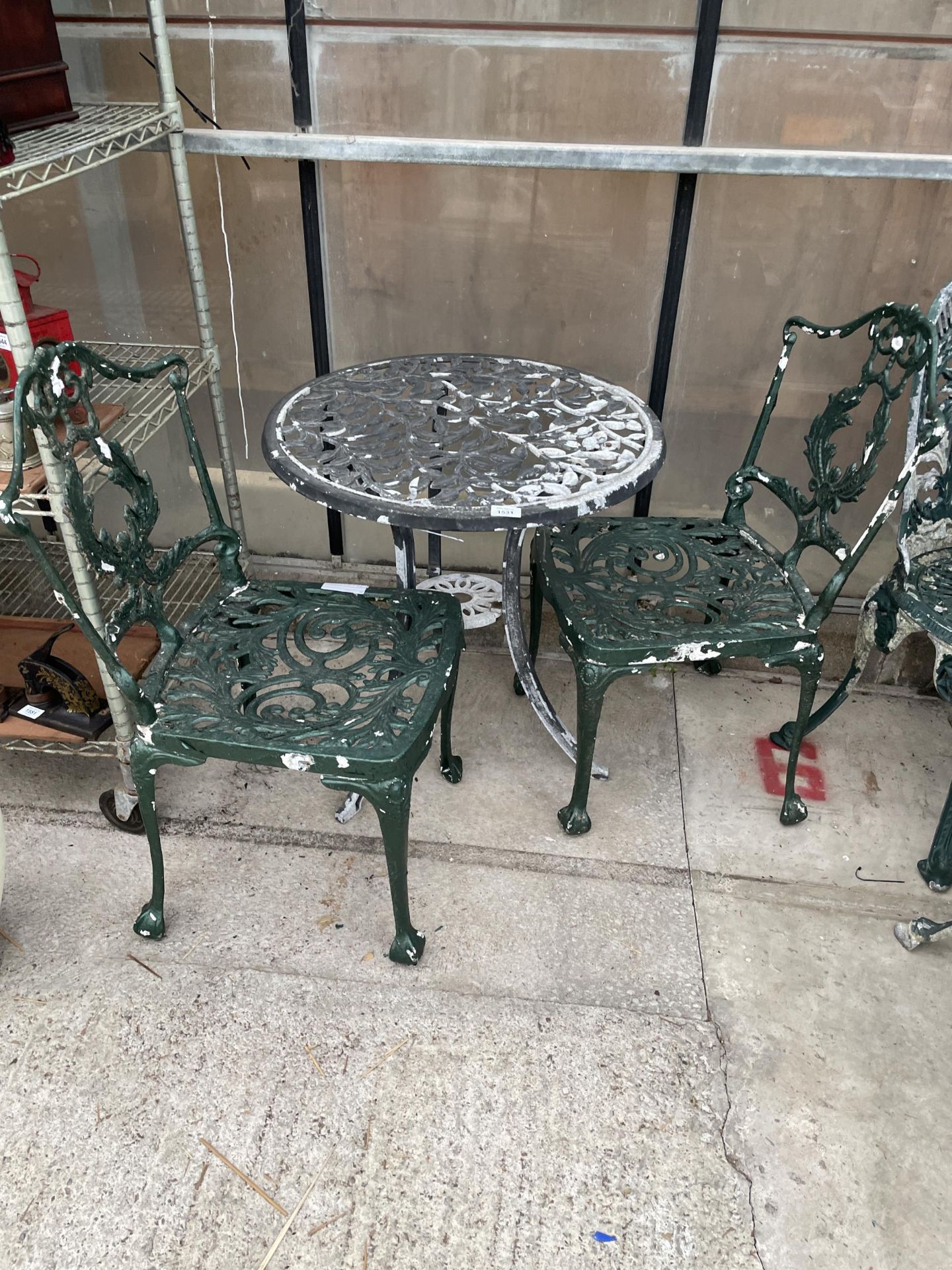 A CAST ALLOY BISTRO TABLE AND TWO CAST ALLOY CHAIRS