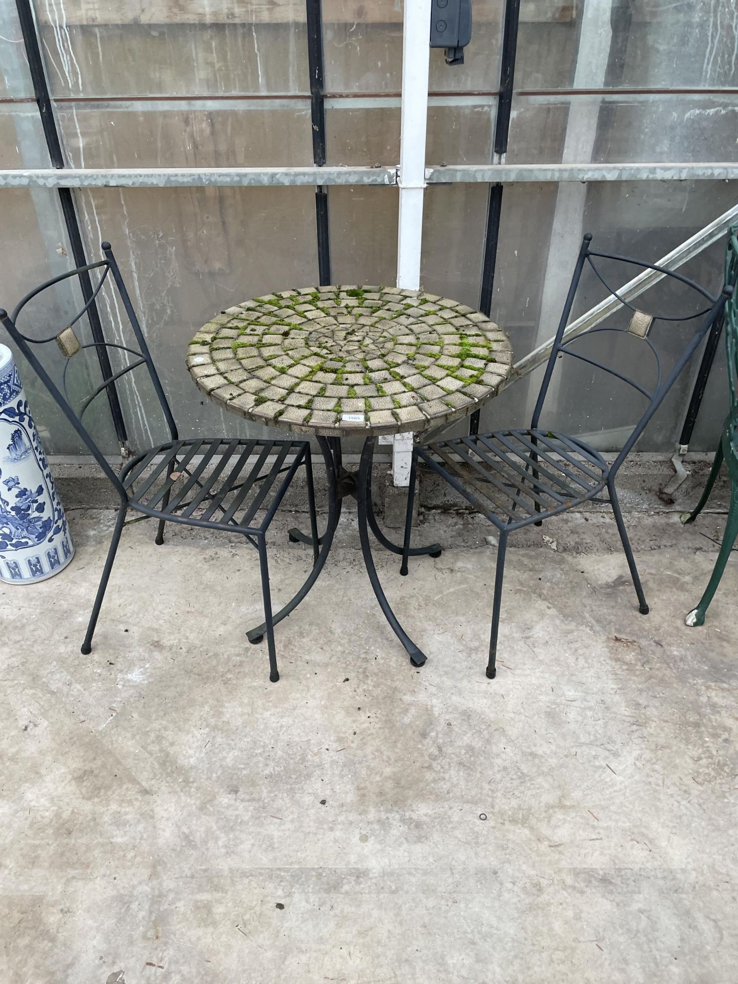 A BISTRO SET COMPRISING OF A ROUND TILE TOP TABLE AND TWO METAL CHAIRS
