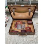 A VINTAGE LEATHER BREIFCASE CONTAINING FOUNTAIN PENS AND HIP FLASKS ETC