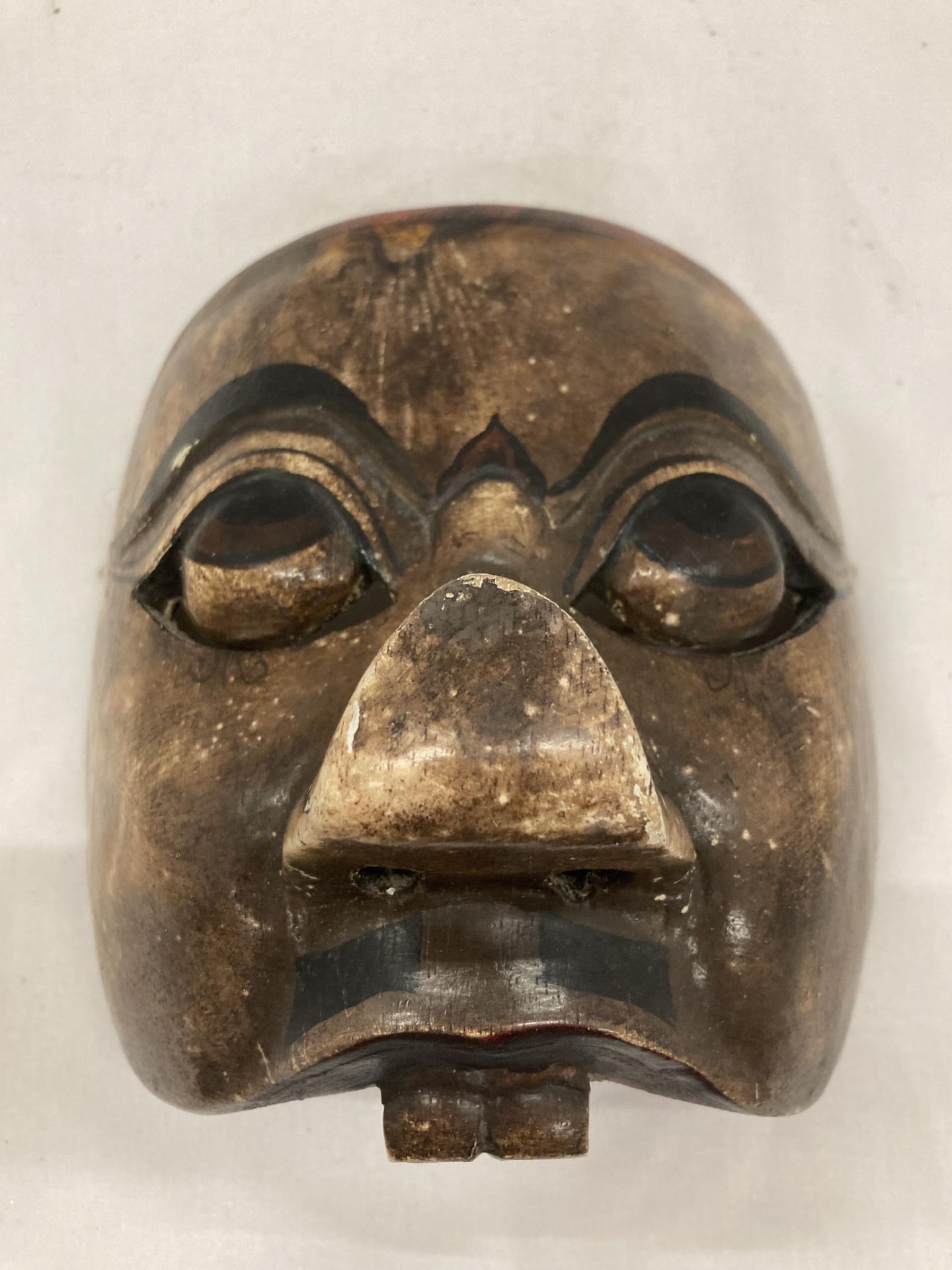 A WOODEN TRIBAL MASK