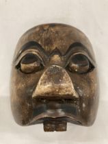 A WOODEN TRIBAL MASK