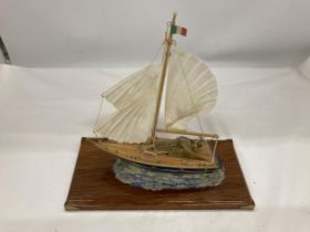 A MODEL OF A VINTAGE ITALIAN YACHT, ON A WOODEN PLINTH, WITH ENAMEL AND BRASS HULL, HEIGHT APPROX