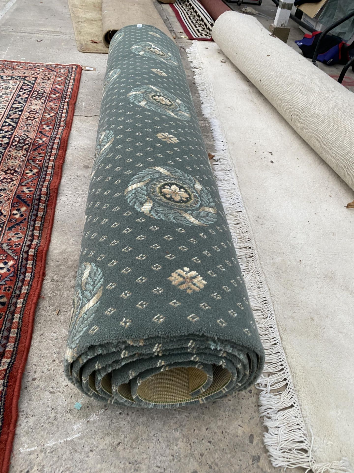 A PART ROLL OF GREEN PATTERNED CARPET