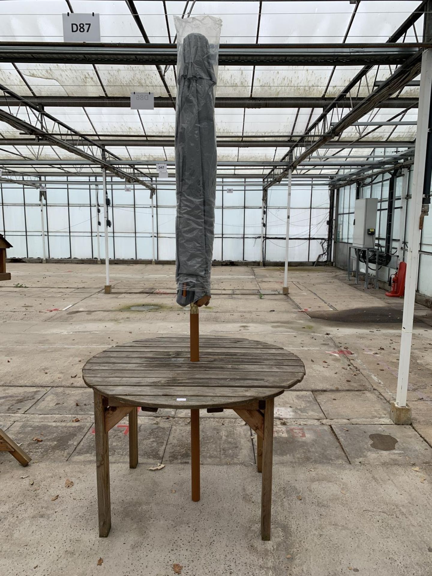 AN AS NEW EX DISPLAY CHARLES TAYLOR CIRCULAR TABLE WITH A GREY PARASOL + VAT