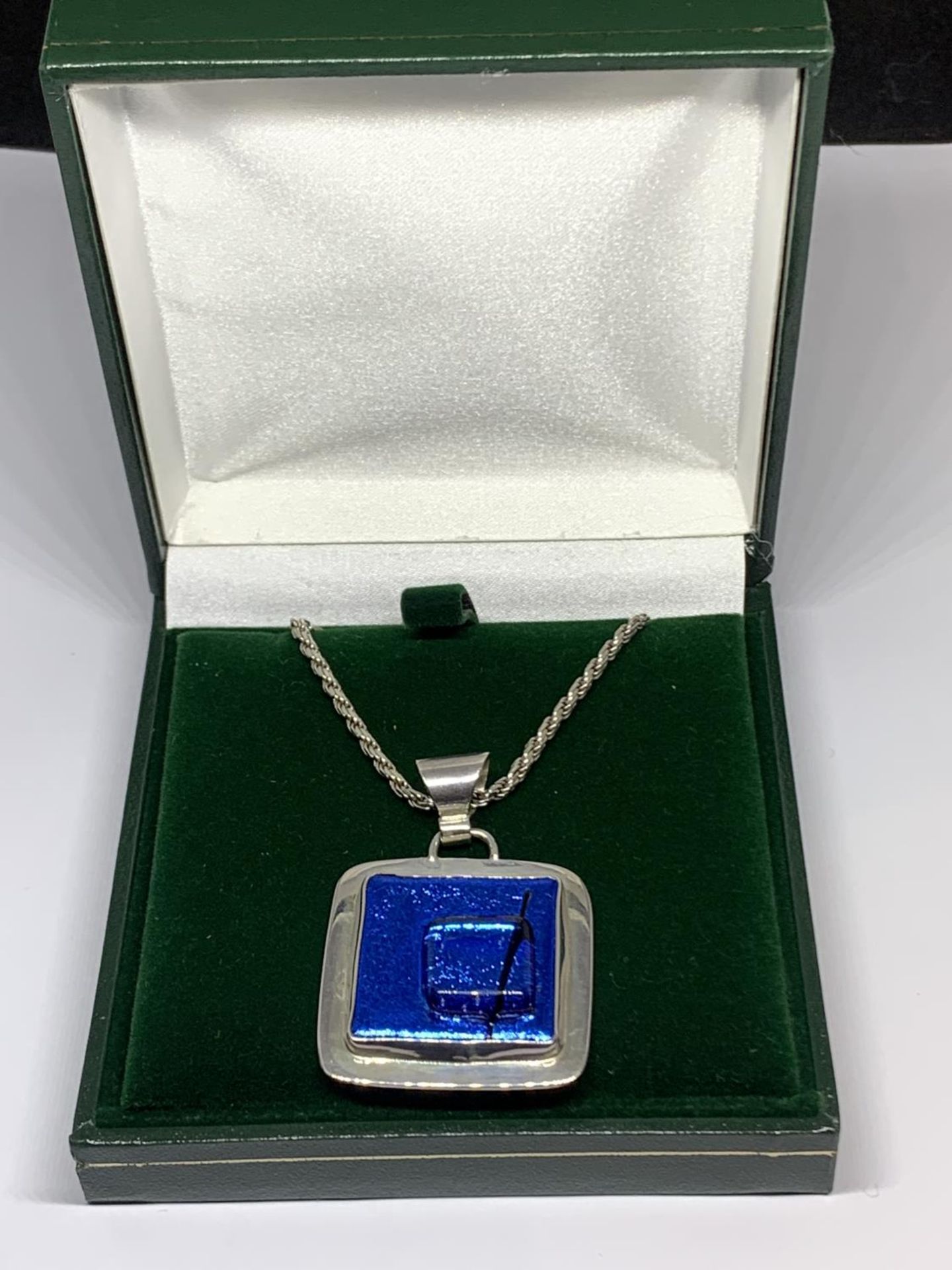 A BOXED SILVER NECKLACE WITH LARGE BLUE STONE PENDANT