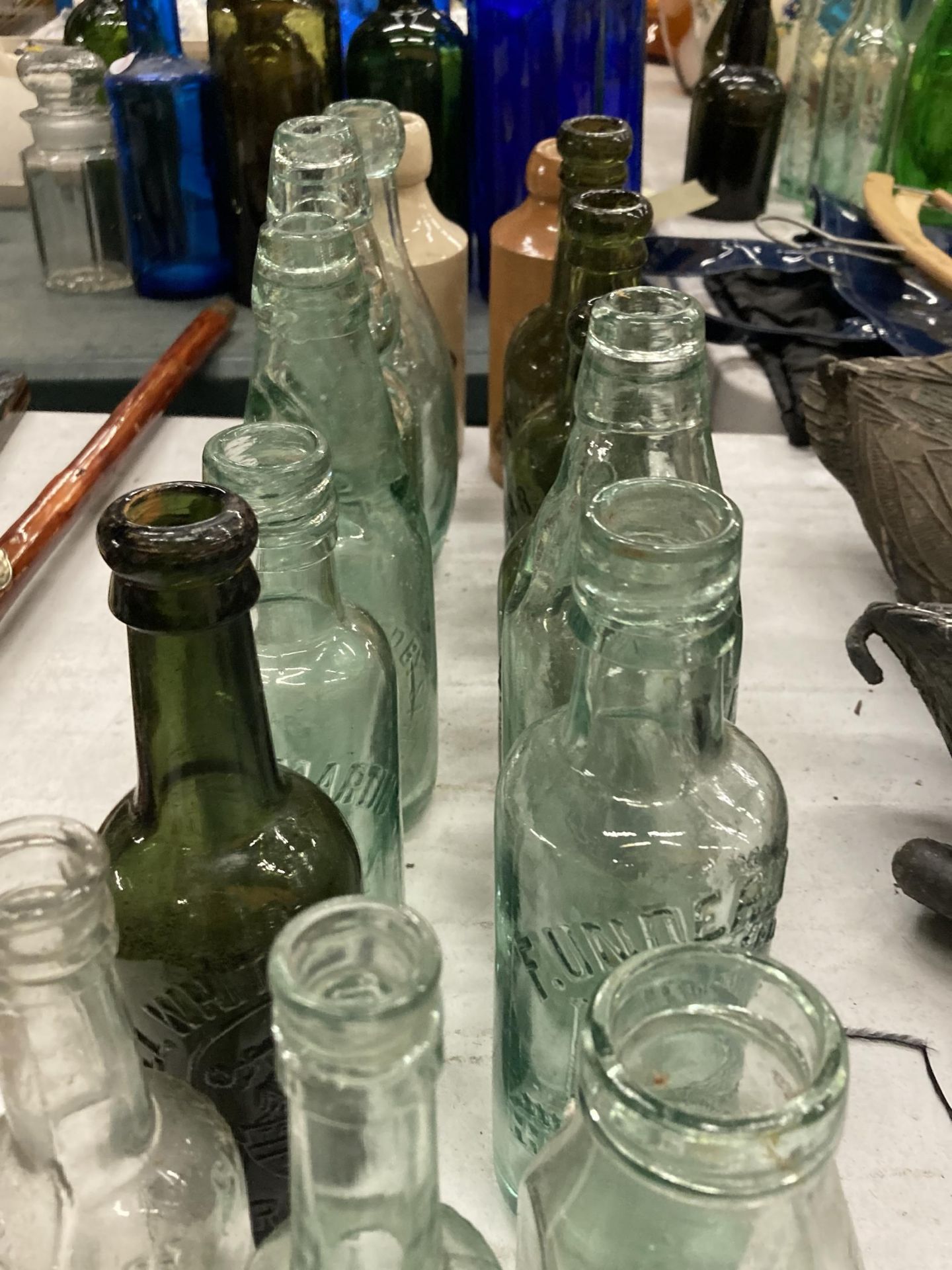 A COLLECTION OF VINTAGE GLASS BOTTLES WITH ADVERTISING ON THEM PLUS TWO STONE ONES - Image 3 of 4