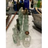 A COLLECTION OF VINTAGE GLASS BOTTLES WITH ADVERTISING ON THEM PLUS TWO STONE ONES