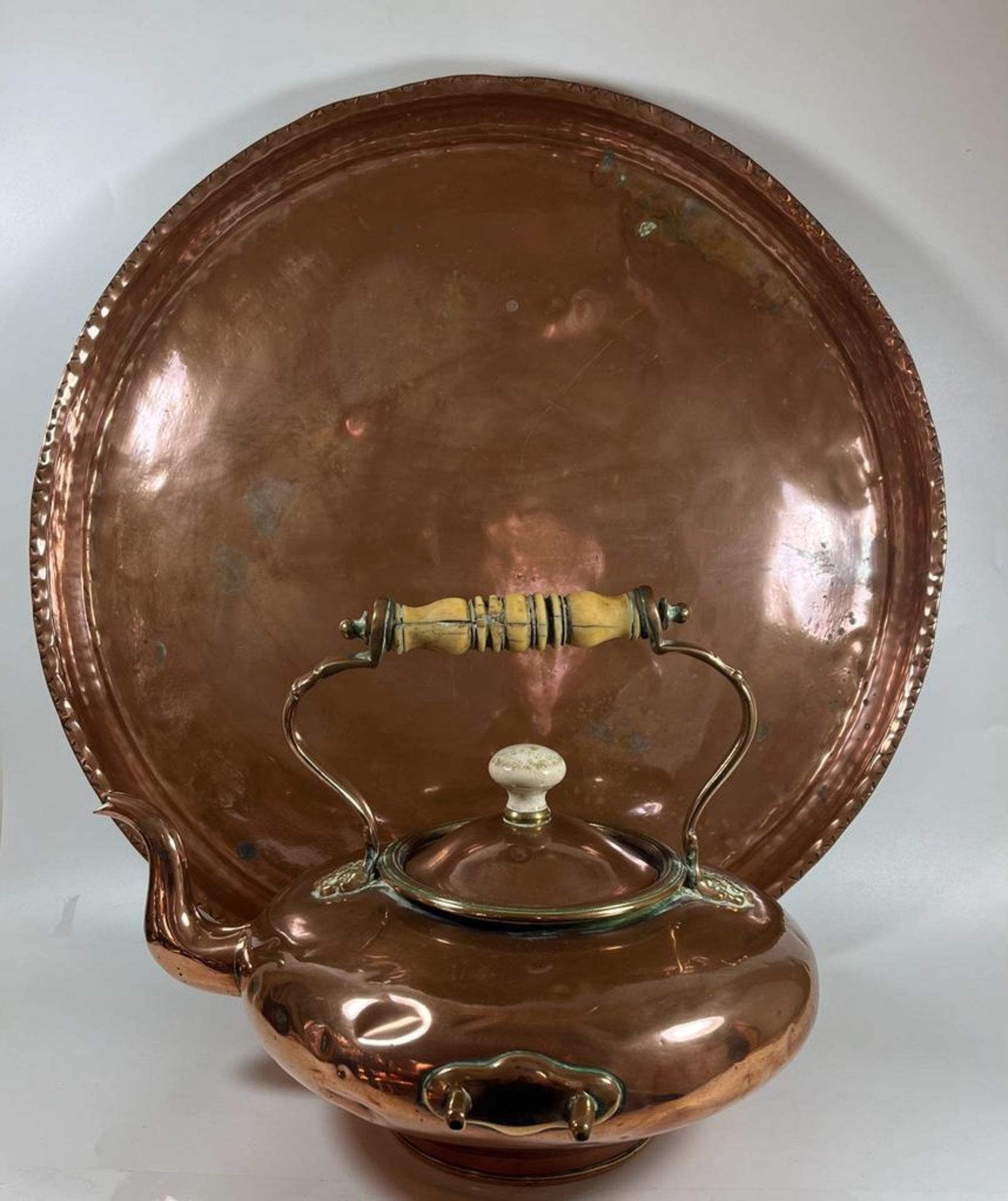 TWO VINTAGE COPPER ITEMS - A SPIRIT KETTLE WITH WOODEN HANDLE AND LARGE ARTS AND CRAFTS CIRCULAR