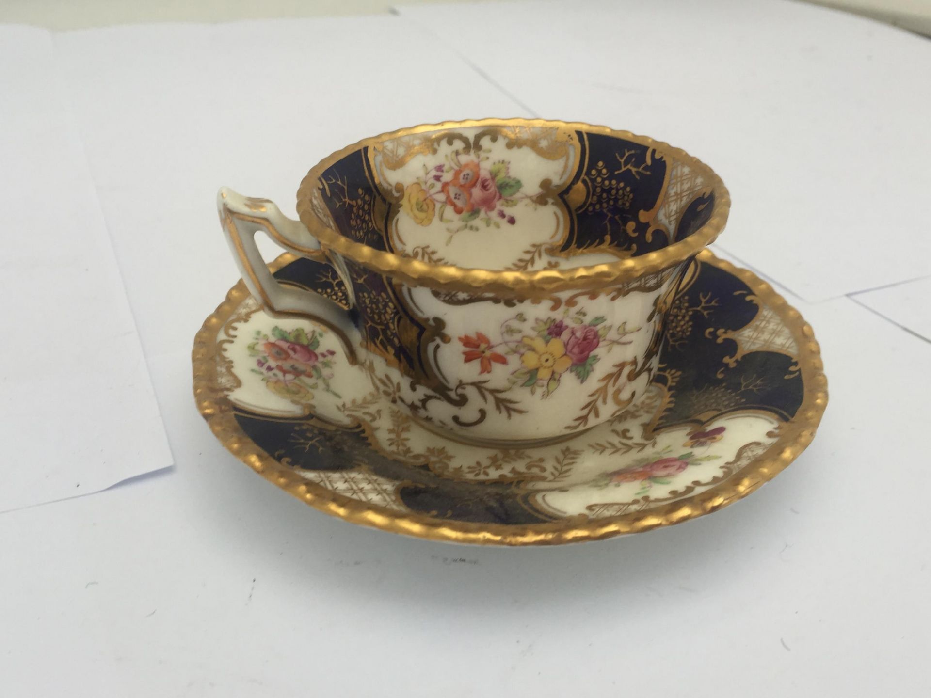 AN ANTIQUE COALPORT BLUE AND GILT Y3517 CUP AND SAUCER