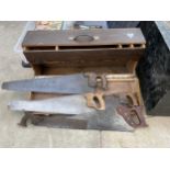 A VINTAGE WOODEN JOINERS CHEST WITH AN ASSORTMENT OF VINTAGE SAWS