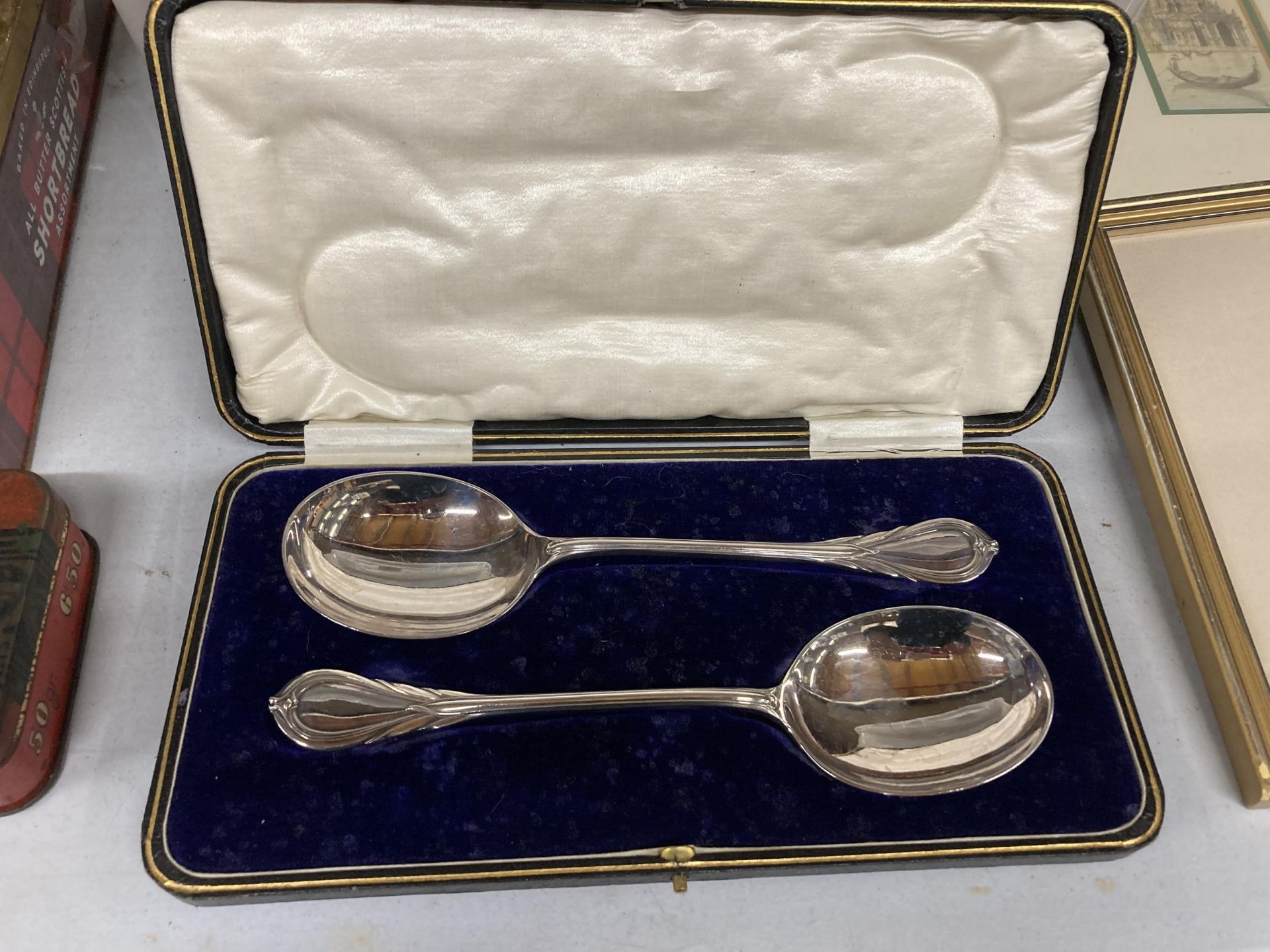 A VINTAGE BOXED SET CONTAINING SILVER PLATED SERVING SPOONS