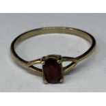 A 9 CARAT GOLD RING WITH A RED GARNETT STONE SIZE Q/R