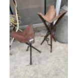 TWO VINTAGE LEATHER FOLDING TRIPOD STOOLS