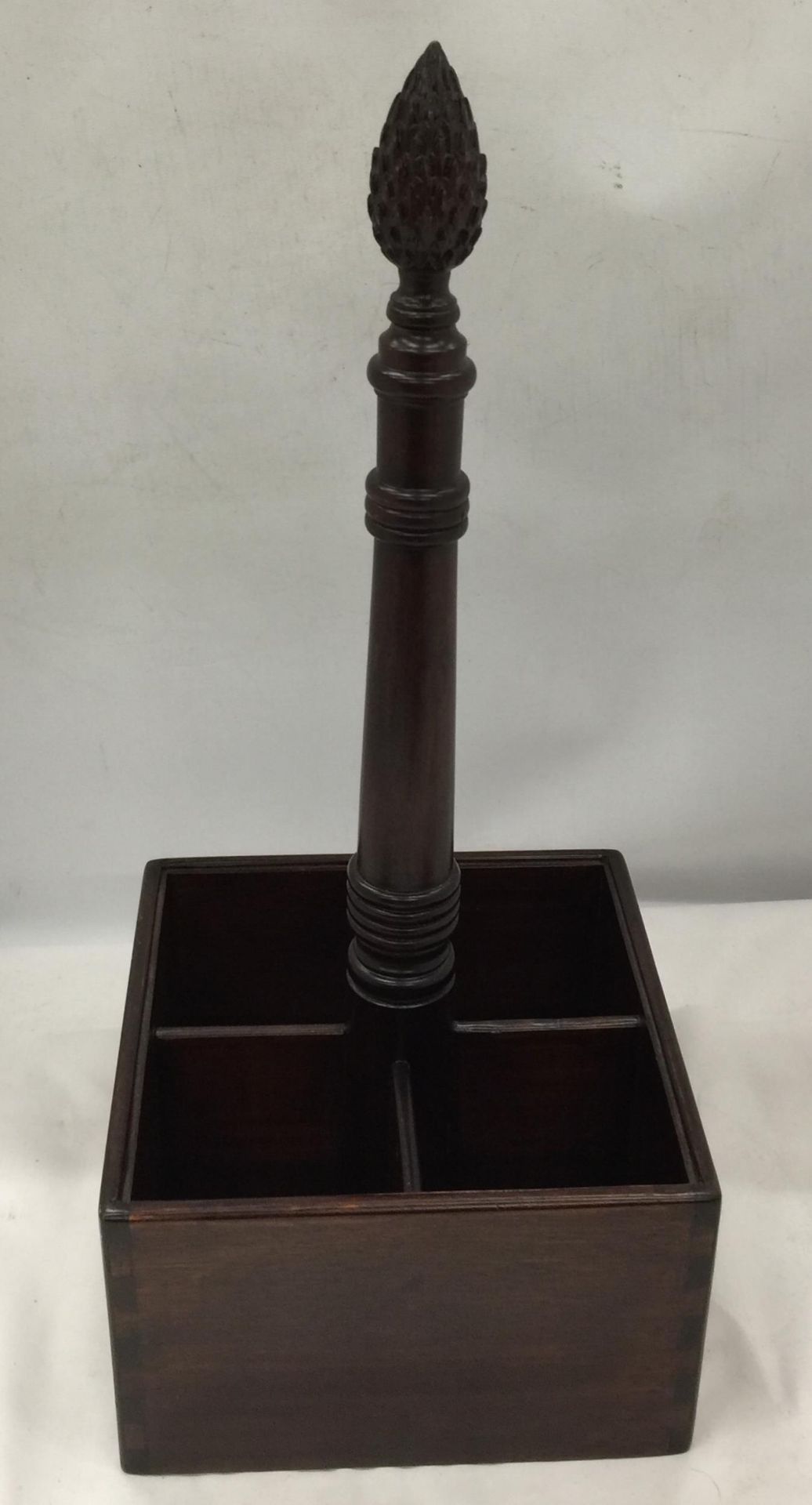 A VINTAGE MAHOGANY FOUR SECTION BOTTLE HOLDER WITH CARVED TOP