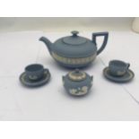 A GROUP OF WEDGWOOD BLUE JASPERWARE ITEMS - TEAPOT, SUGAR BOWL AND TWO MINIATURE CUPS AND SAUCERS