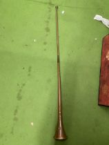 A LONG VINTAGE BRASS HUNTING HORN WITH BRASS MOUTHPIECE