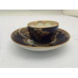 A 19TH CENTURY CONTINENTAL BLUE AND GILT PORCELAIN CUP AND SAUCER, BLUE CROSS SWORDS MARK TO BASE