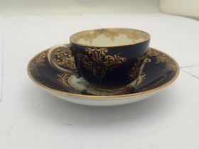 A 19TH CENTURY CONTINENTAL BLUE AND GILT PORCELAIN CUP AND SAUCER, BLUE CROSS SWORDS MARK TO BASE