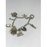 A SILVER CHARM BRACELET WITH NINE CHARMS AND A HEART PADLOCK