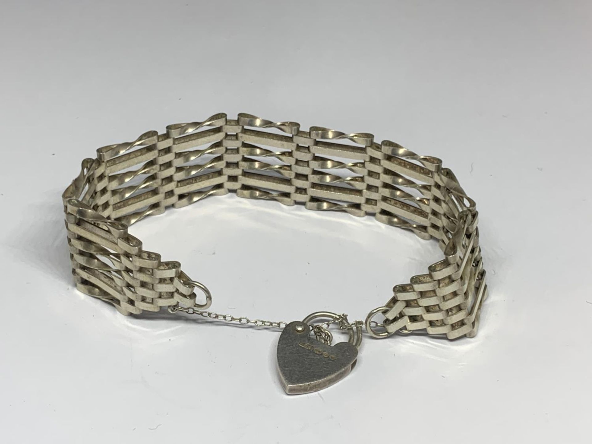 A SILVER SIX BAR GATE BRACELET WITH HEART PADLOCK