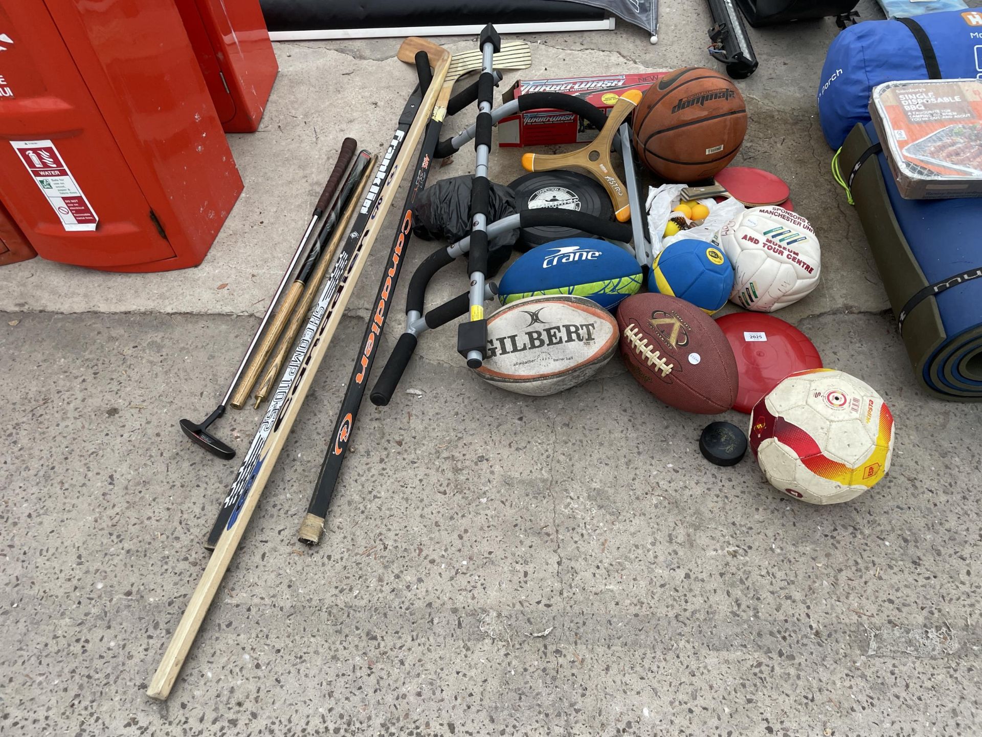 AN ASSORTMENT OF SPORTS EQUIPMENT TO INCLUDE BALLS, RACKETS AND HOCKEY STICKS ETC