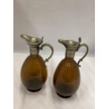 A PAIR OF VINTAGE SILVER PLATED AND AMBER GLASS JUGS