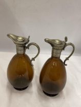 A PAIR OF VINTAGE SILVER PLATED AND AMBER GLASS JUGS