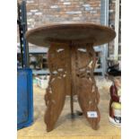A SMALL HEAVILY CARVED ASIAN STYLE TABLE WITH THREE LEGS, HEIGHT 38CM, DIAMETER 37CM