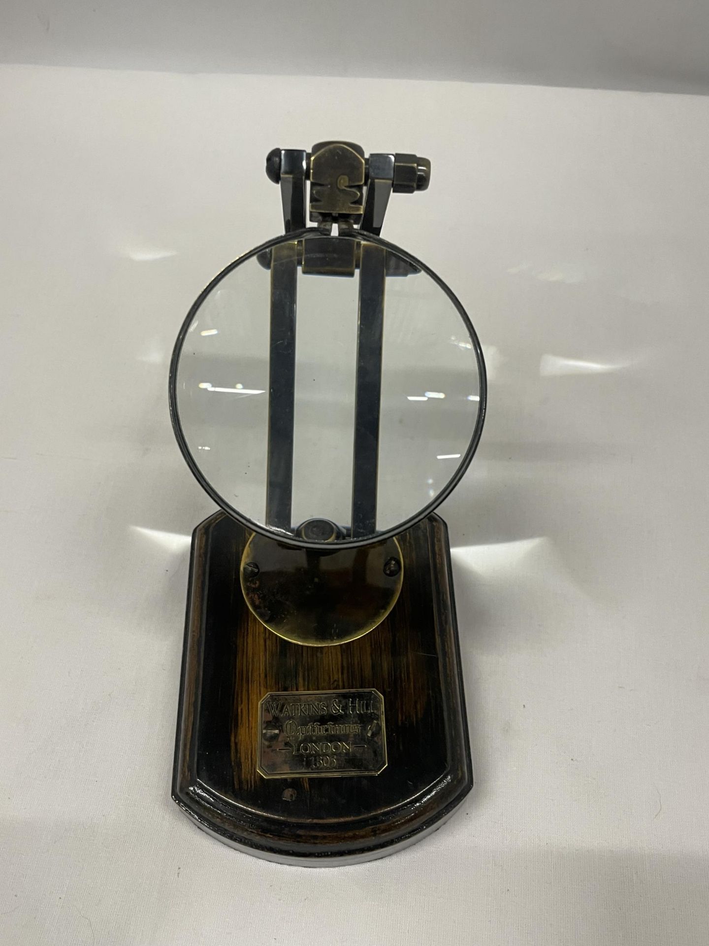 A WATKINS AND HILL MAGNIFYING GLASS ON WOODEN BASE
