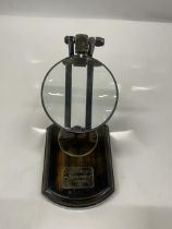 A WATKINS AND HILL MAGNIFYING GLASS ON WOODEN BASE