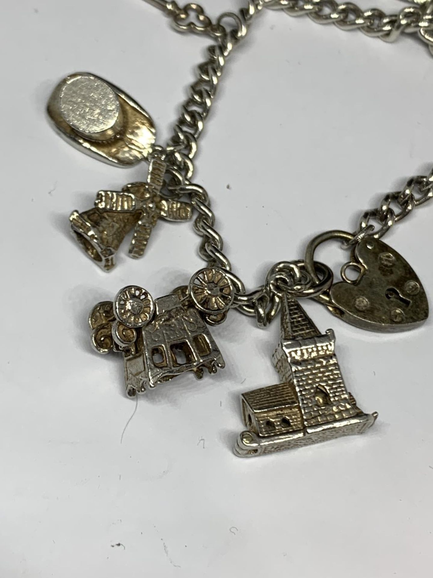 A SILVER CHARM BRACELET WITH NINE CHARMS AND A HEART PADLOCK - Image 2 of 4