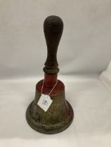 A LARGE VINTAGE METAL BELL WITH A WOODEN HANDLE