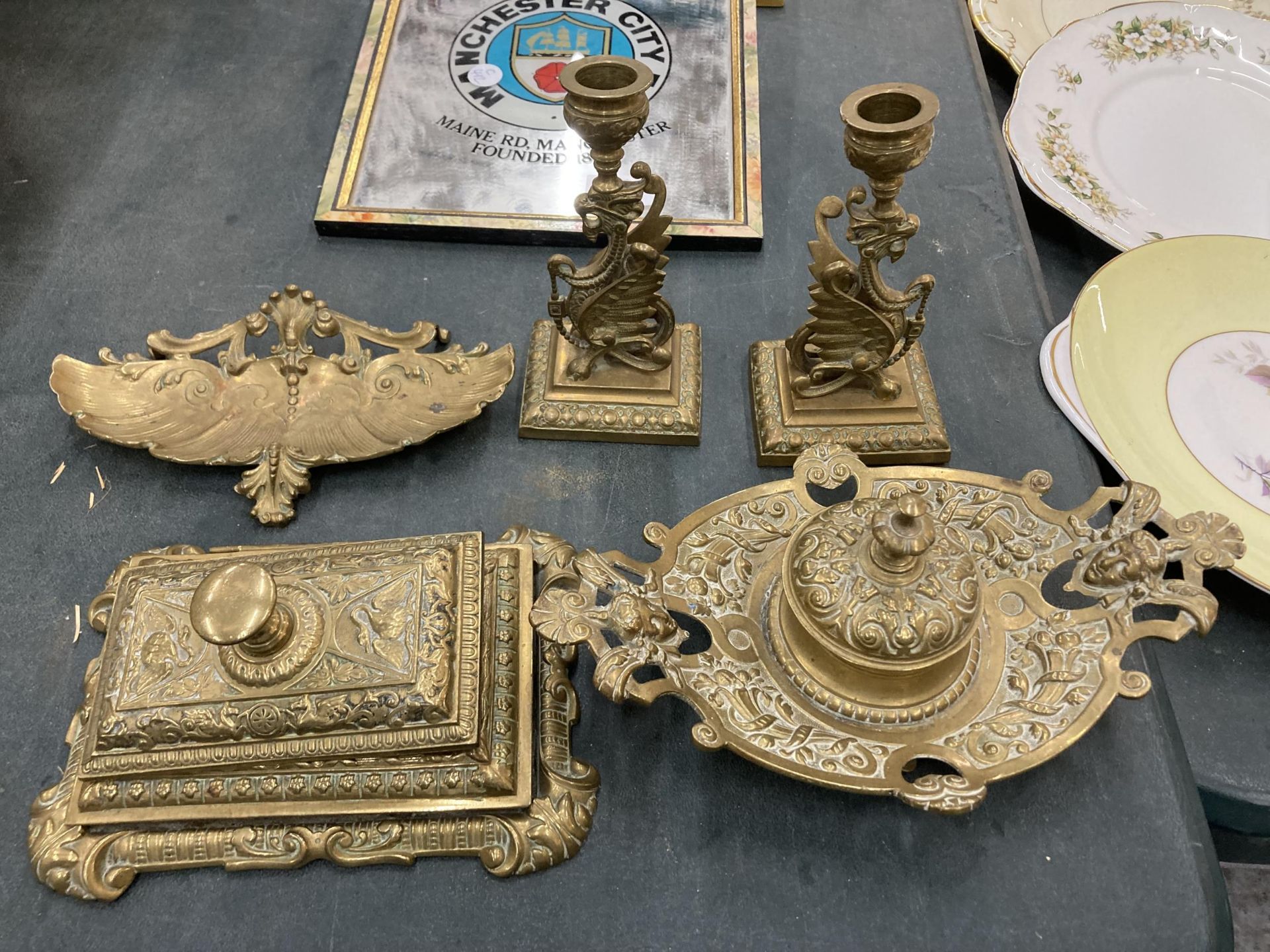 THREE ORNATE VINTAGE BRASS INKWELLS TOGETHER WITH A PAIR OF GRIFFIN DESIGN CANDLESTICKS