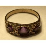 A 9 CARAT GOLD RING WITH THREE IN LINE AMETHYSTS AND DIAMONDS SIZE O