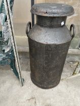 A VINTAGE CAST IRON MILK CHURN WITH LID