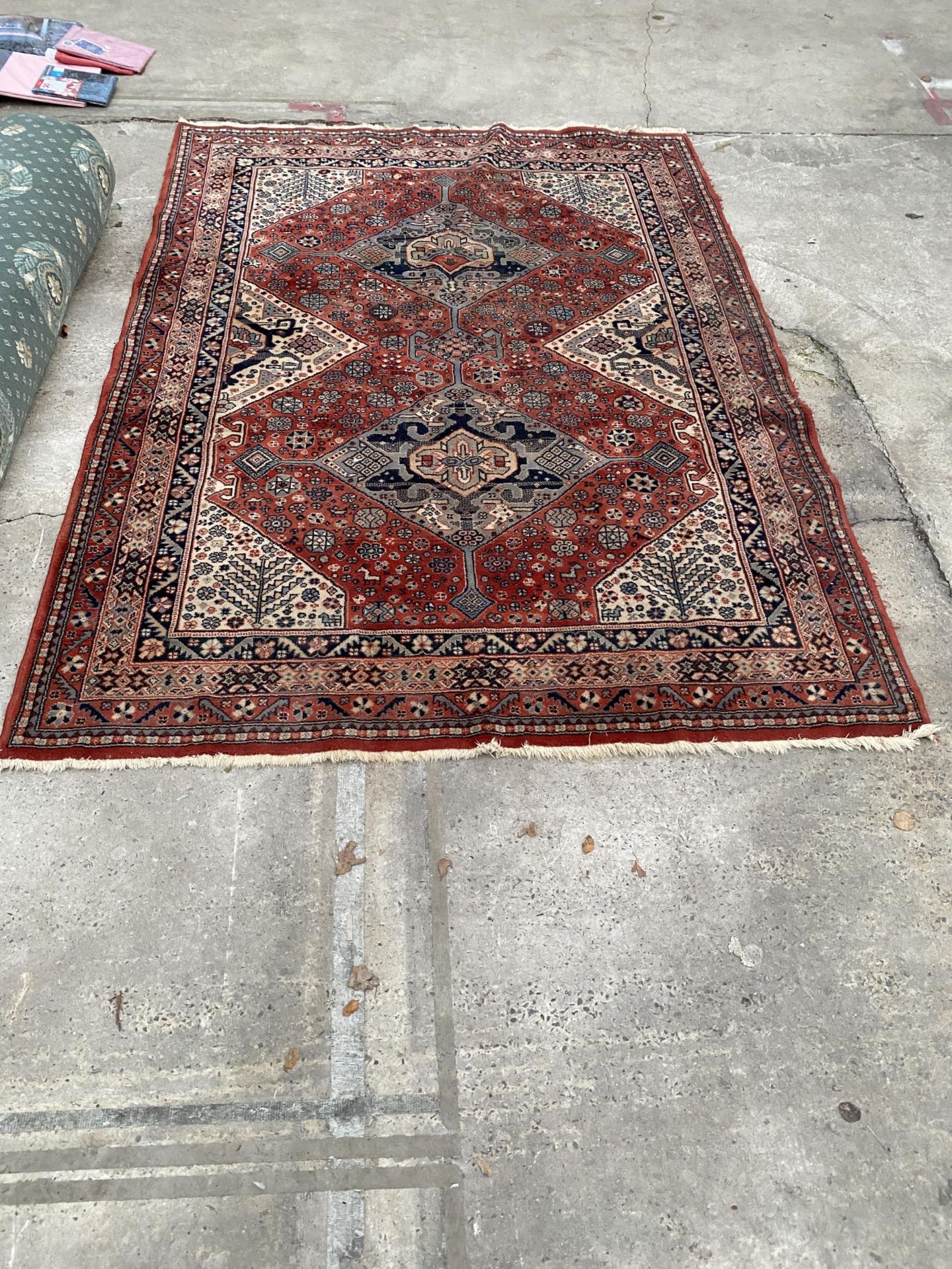 A RED PATTERNED FRINGED RUG