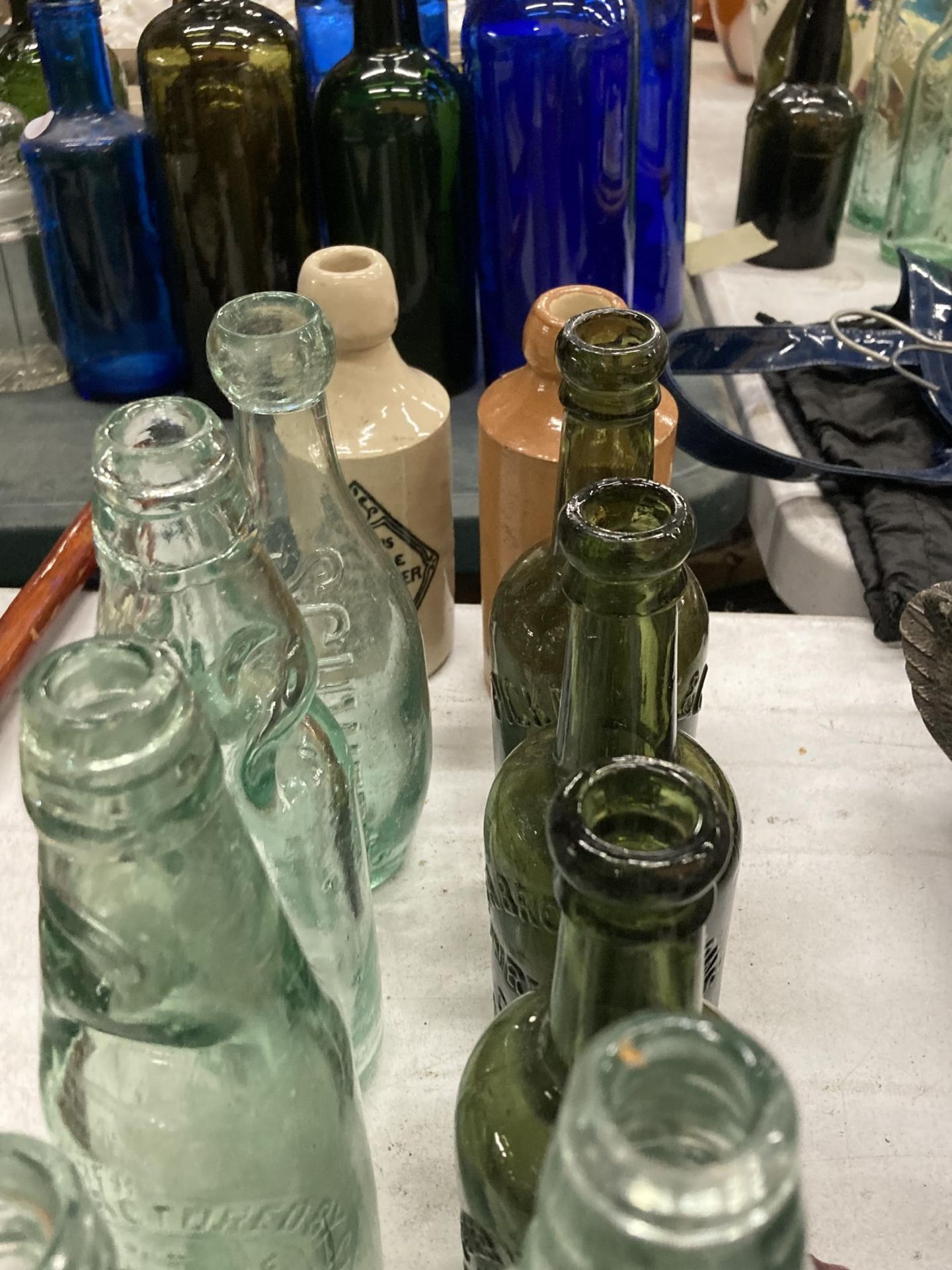 A COLLECTION OF VINTAGE GLASS BOTTLES WITH ADVERTISING ON THEM PLUS TWO STONE ONES - Image 4 of 4