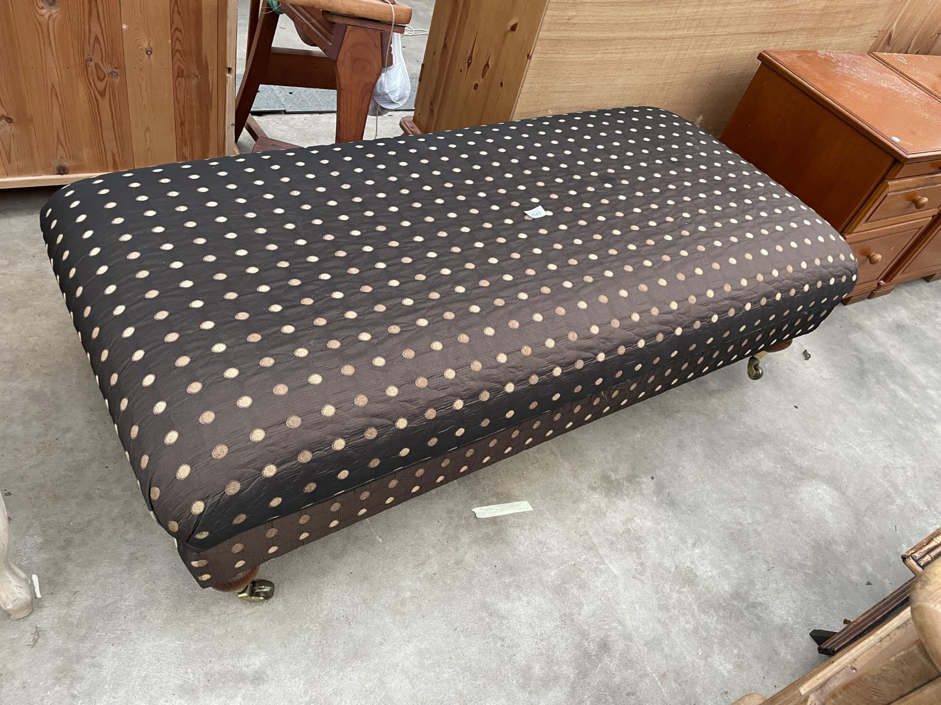 A VICTORIAN STYLE STOOL ON TURNED LEGS, WITH BRASS CASTERS AND POLKA DOT COVERING