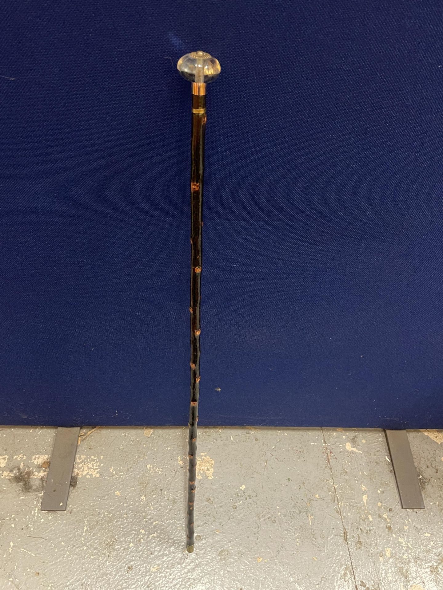 A VINTAGE WALKING STICK WITH GLASS TOP AND METAL BANDING