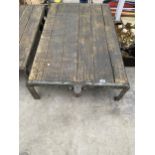 A VINTAGE WOODEN AND METAL TWO WHEELED PLATFORM TROLLEY